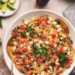 quinoa salad in a bowl with lime wedges on table