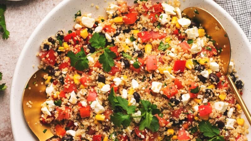 quinoa salad in a bowl with lime wedges on table