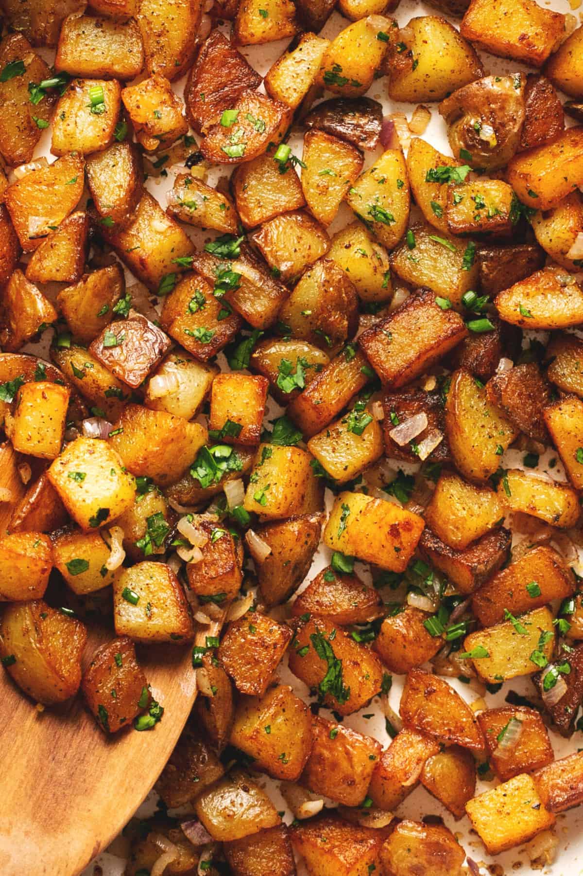 up close breakfast potatoes with serving spoon