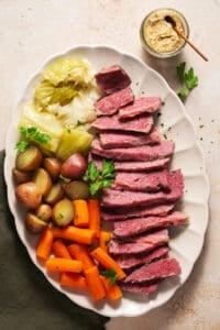 sliced corn beef with cabbage, potatoes, and carrots on a platter