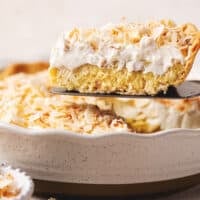 pie server lifting slice of coconut cream pie from dish