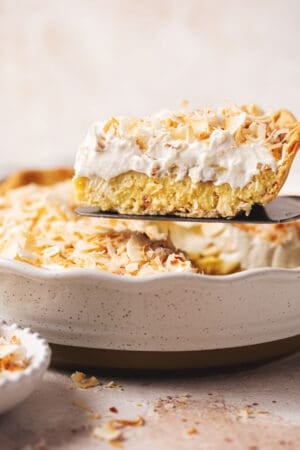 pie server lifting slice of coconut cream pie from dish