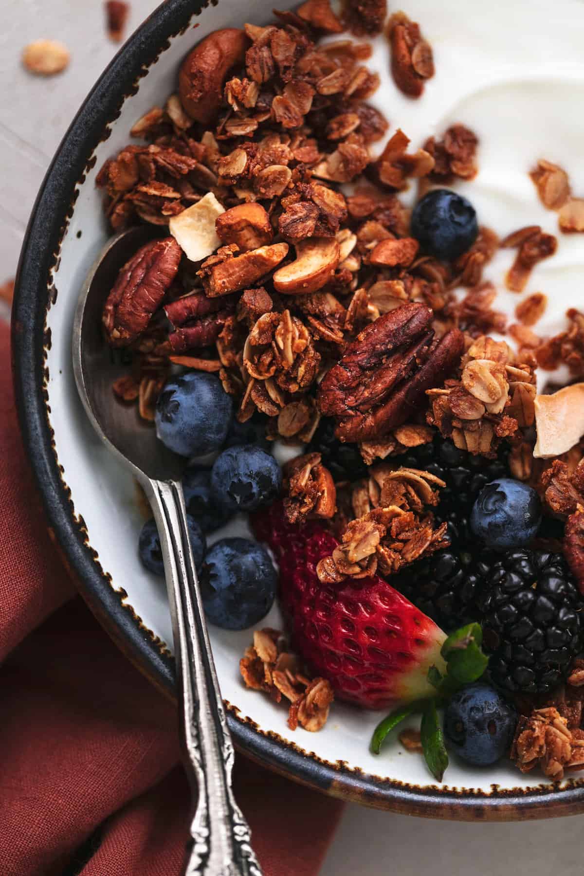 nuts and oats with fresh berries in a bowl with spoon