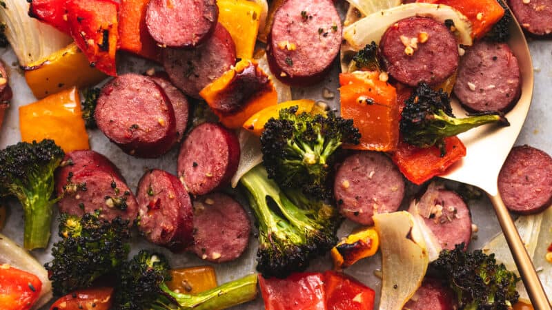 sausage with veggies up close with serving spoon