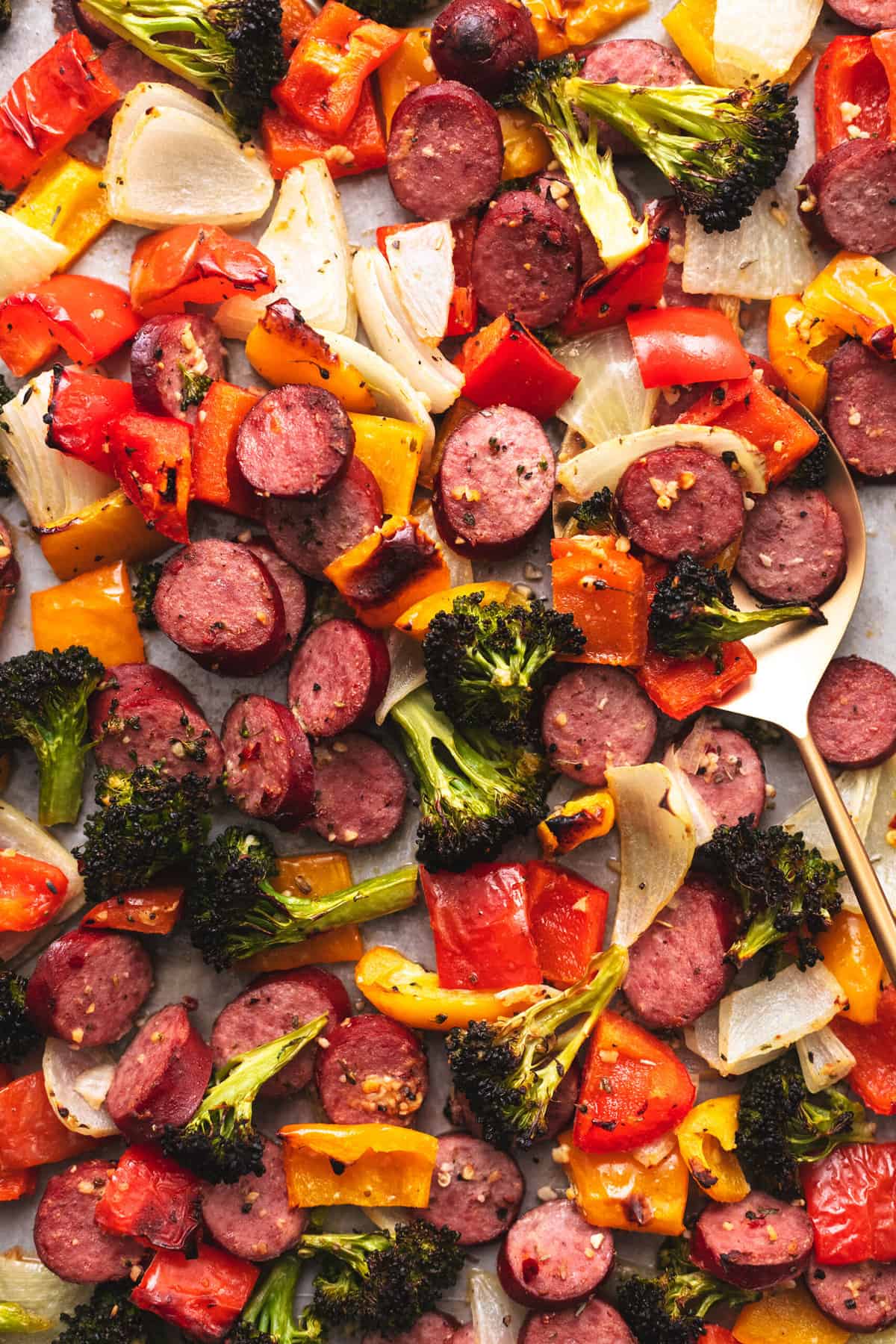 sausage with veggies up close with serving spoon