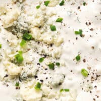 up close blue cheese dressing with crumbles and herbs