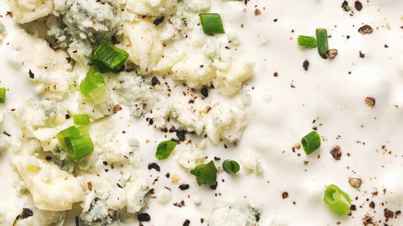 up close blue cheese dressing with crumbles and herbs