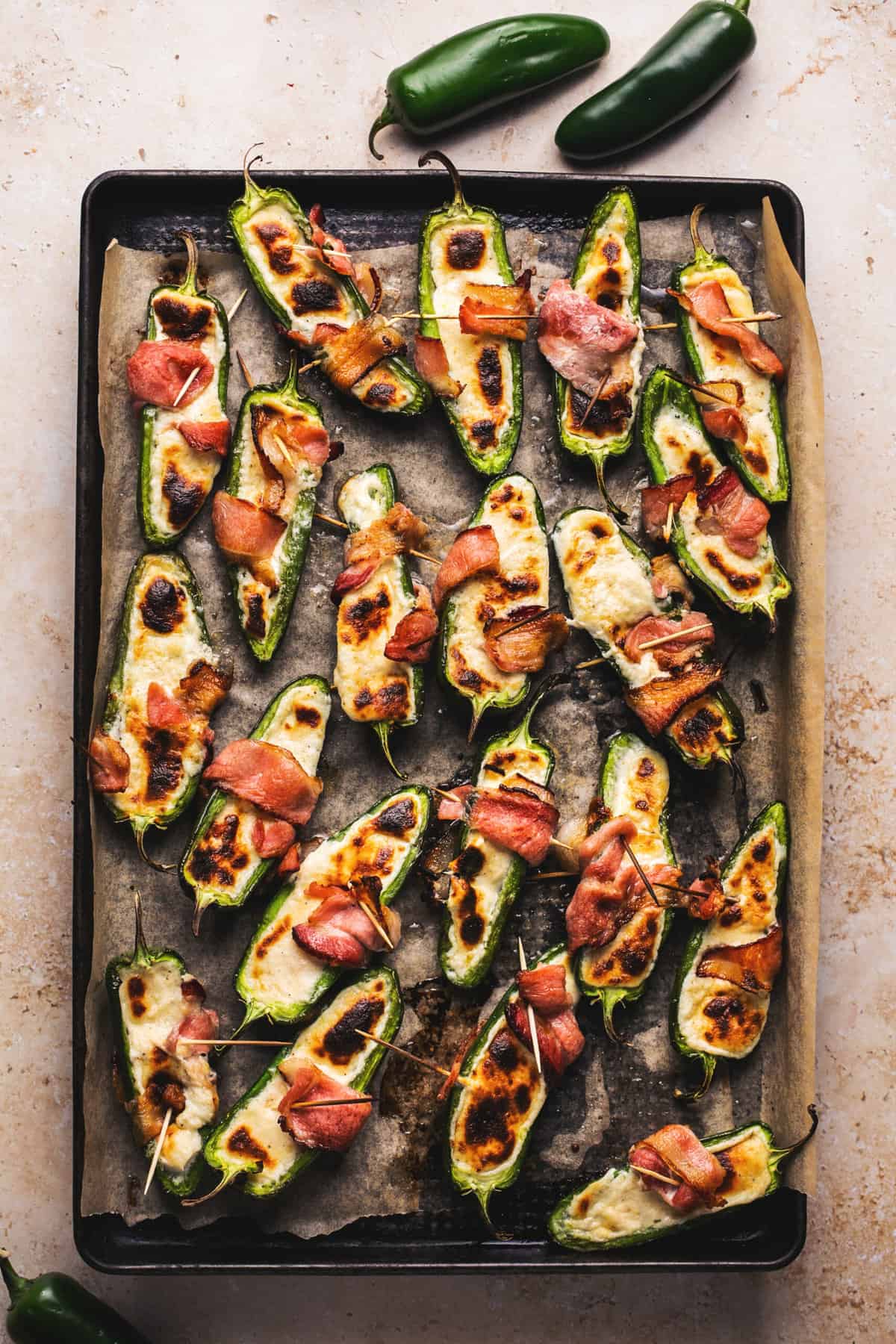 bacon wrapped jalapeno poppers on baking sheet