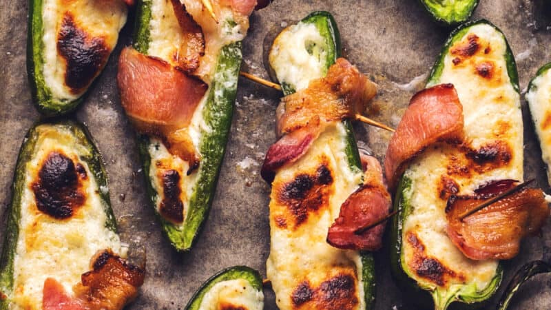 cooked jalapenos stuffed with cheese and wrapped with bacon