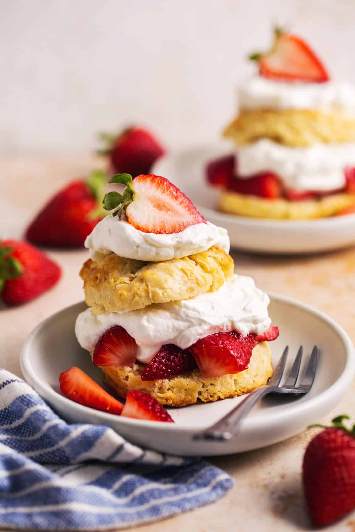 strawberry shortcakes on plates with napkins on table