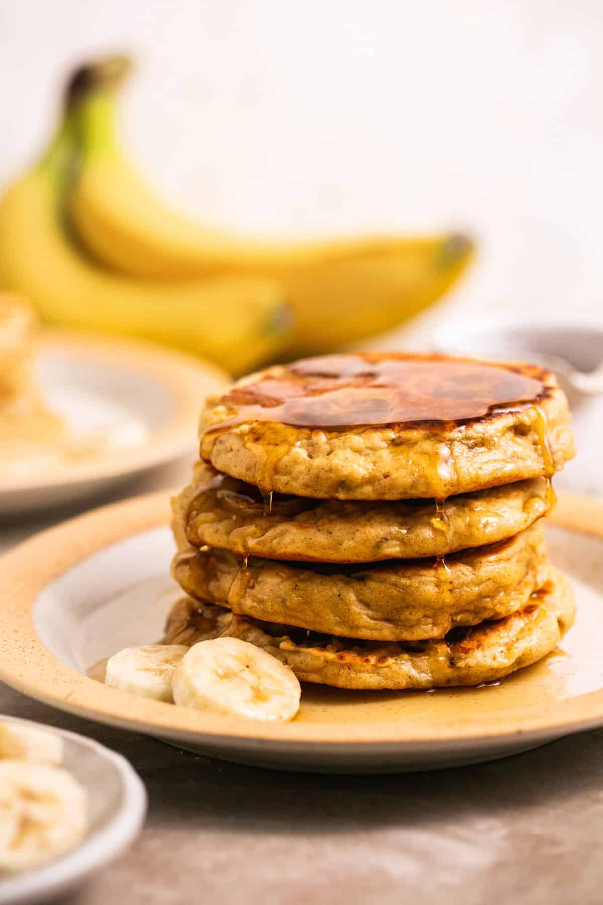 stack of pancakes with bananas and syrup