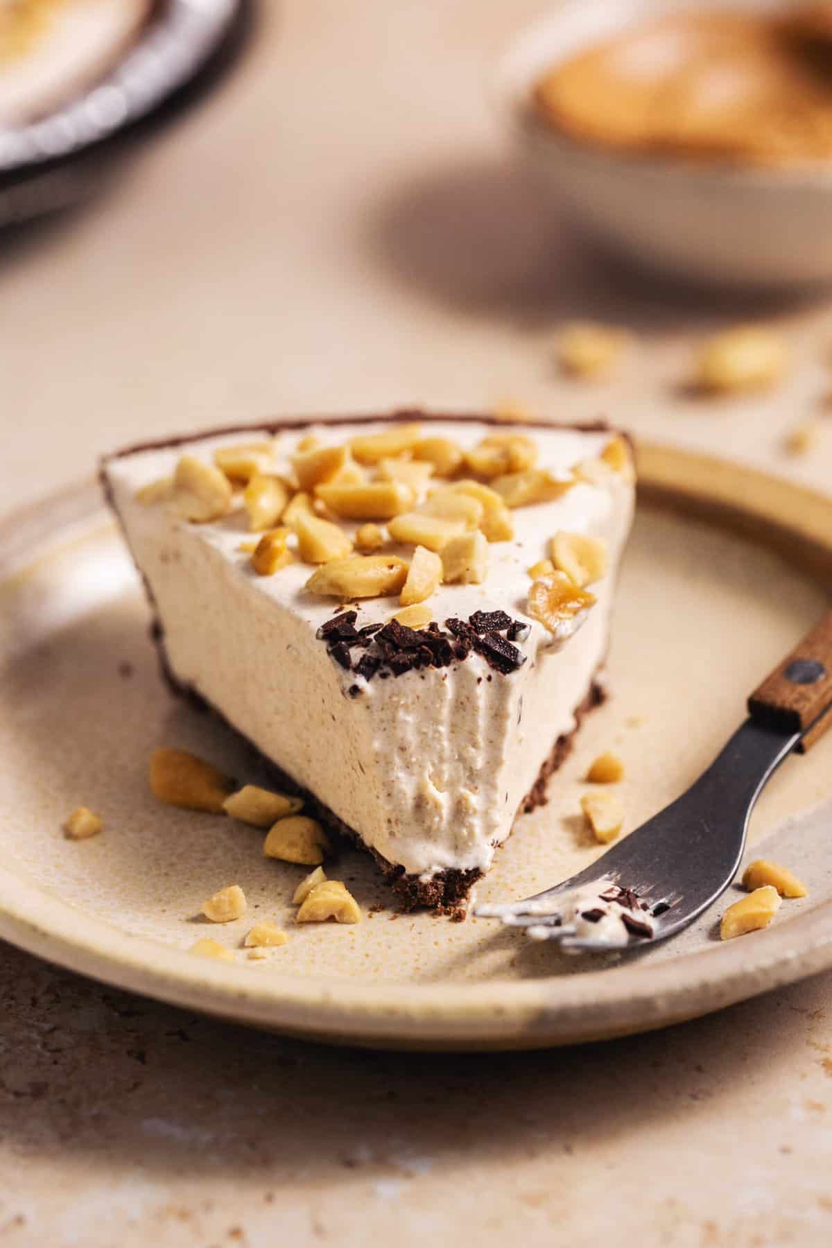 single slice of peanut butter pie with a bite missing on a plate