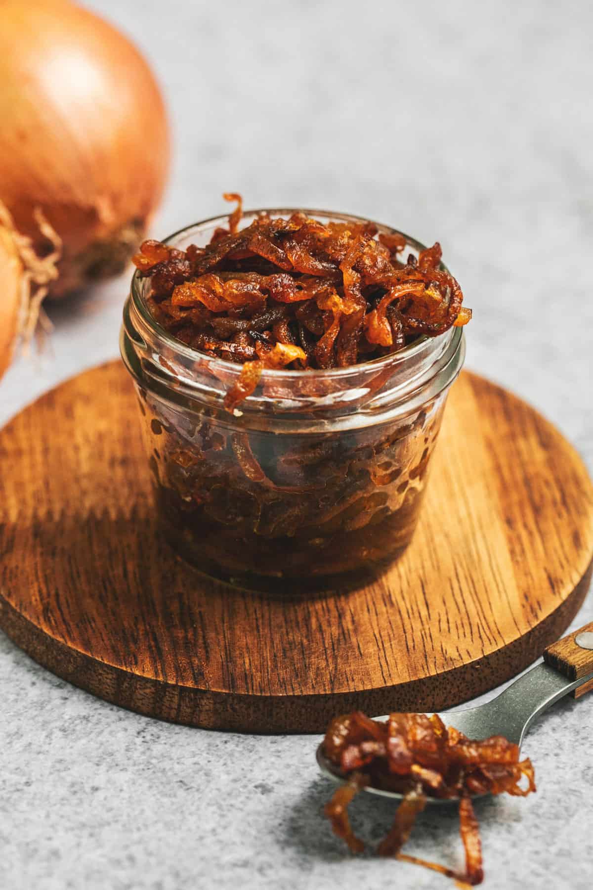 jar of caramelized onions on a wooden cutting board