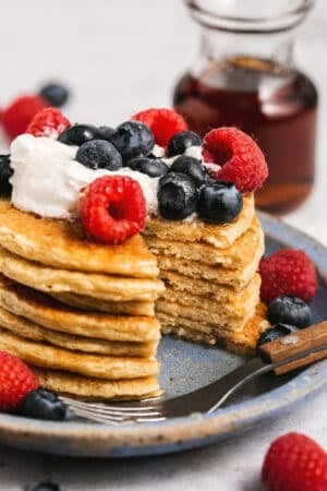 plate of cottage cheese pancakes with berries and whipped cream