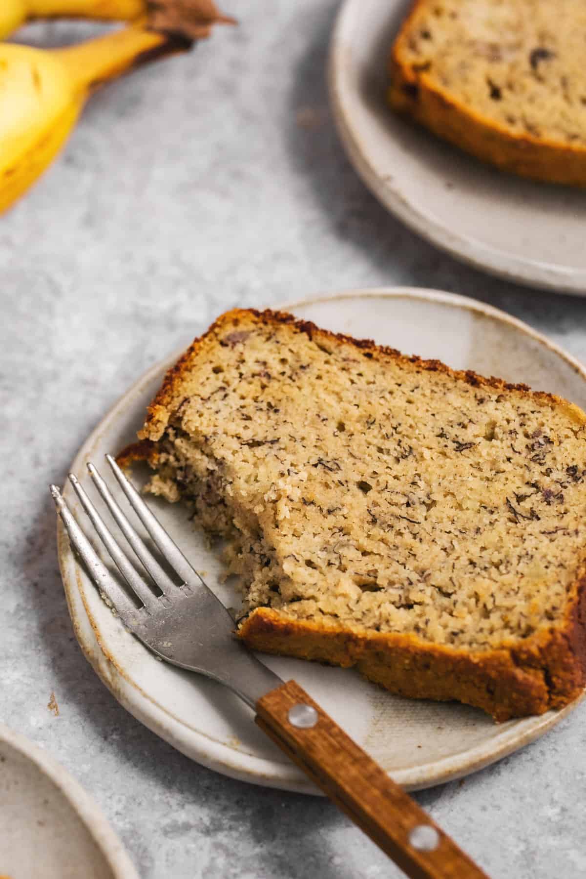 single slice of banana bread on plate with fork
