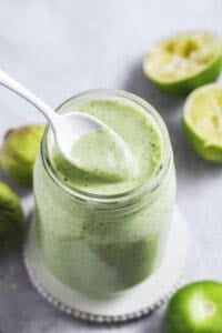 jar of green dressing with spoon scooping from jar