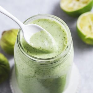 jar of green dressing with spoon scooping from jar