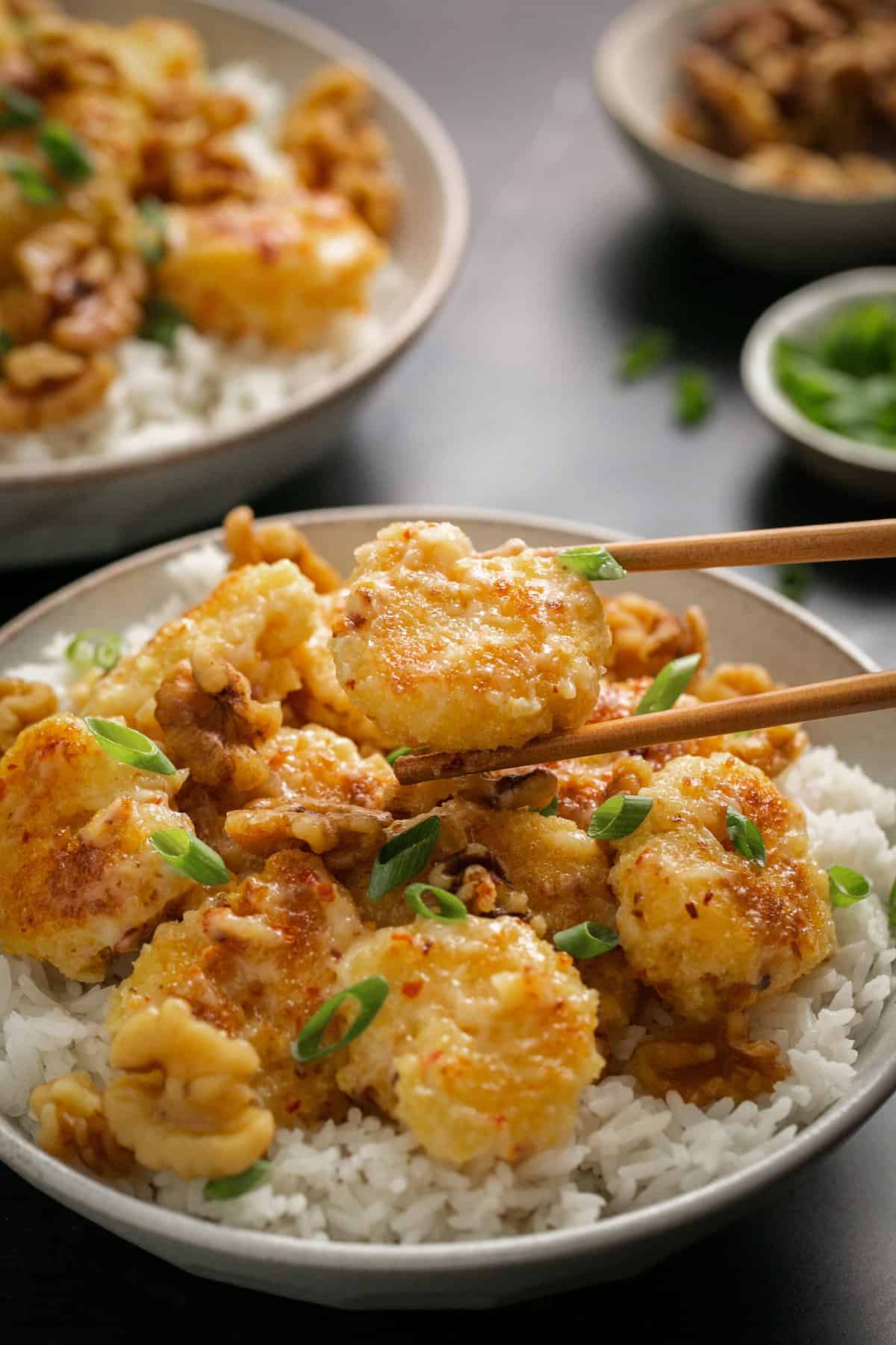 chopsticks lifting shrimp from bowl of rice