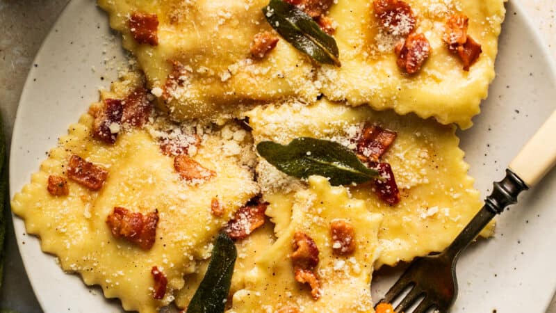 plate of butternut squash ravioli topped with bacon