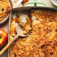 baked caramel apple dump cake in a baking pan with wooden serving spoon