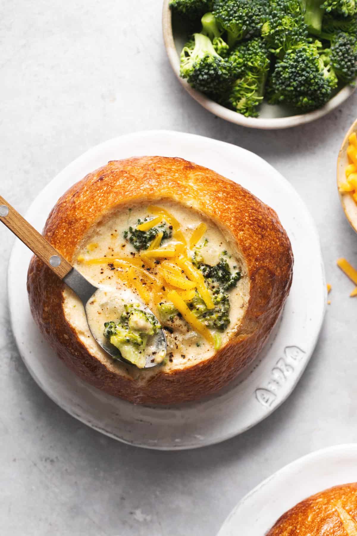 panera bread cheddar broccoli soup in bread bowl with spoon