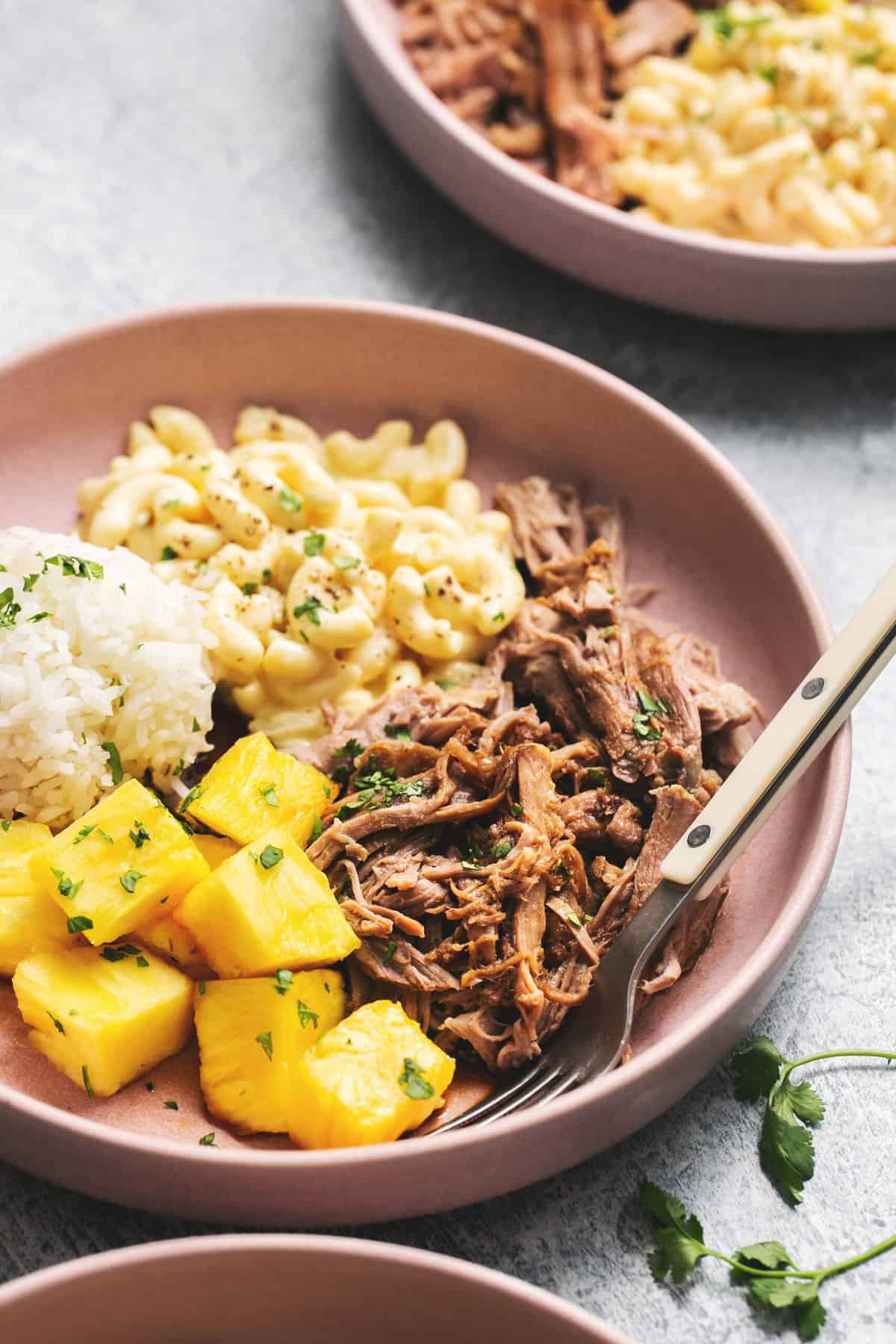 plate of kalua pork with macaroni salad, rice, and pineapple
