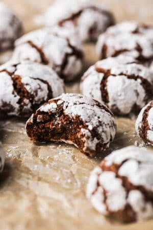chocolate crinkle cookie with bite out on parchment paper