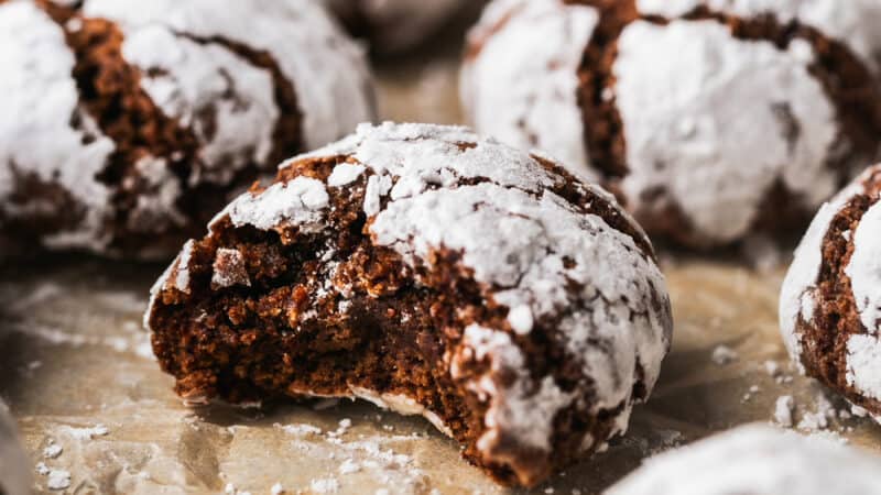 chocolate crinkle cookie with bite out on parchment paper
