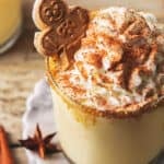 up close eggnog in mug with whipped cream and gingerbread man