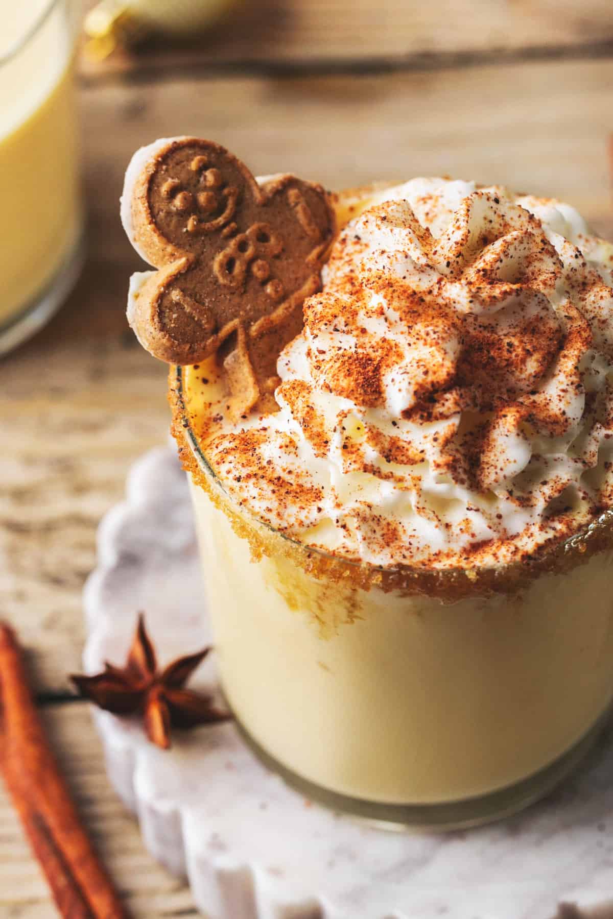 up close eggnog in mug with whipped cream and gingerbread man
