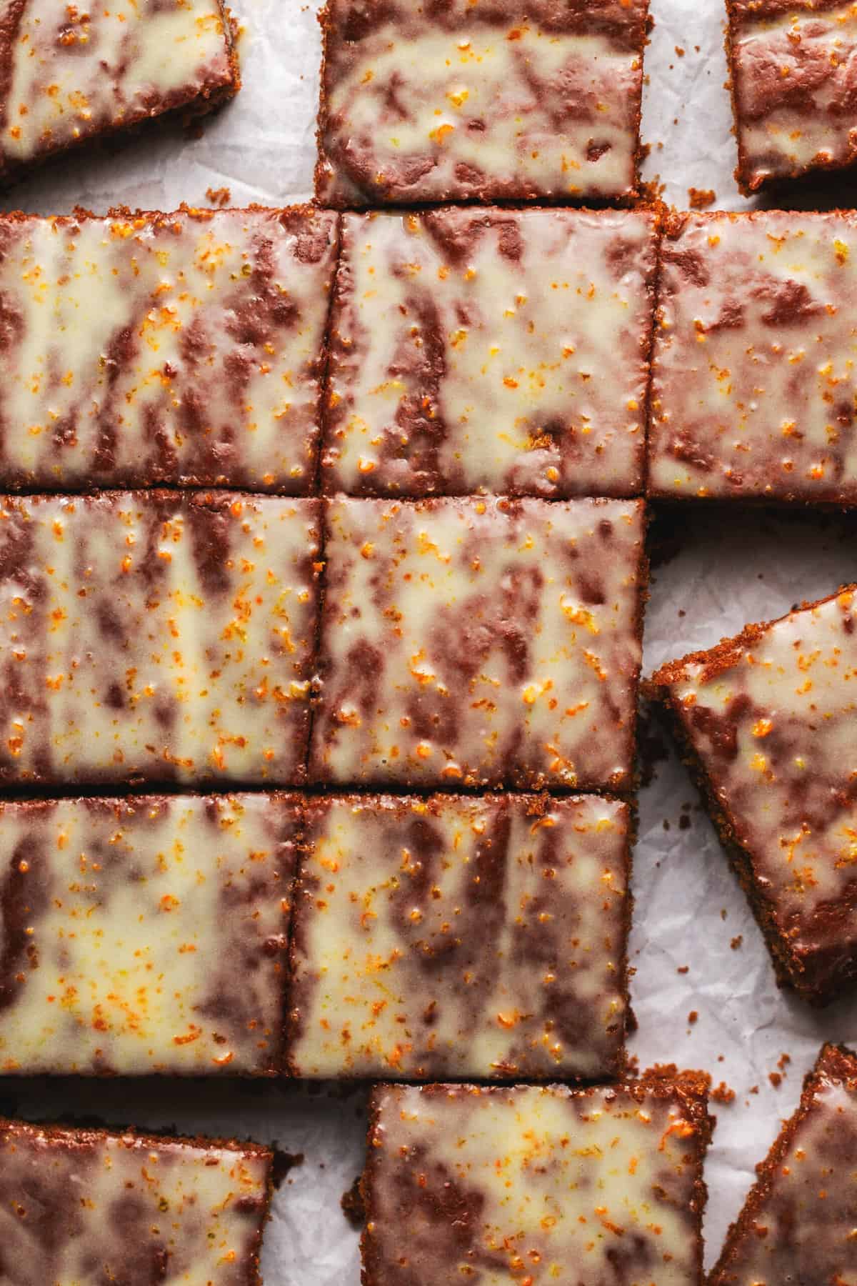 gingerbread cake cut into squares and topped with glaze on parchment paper