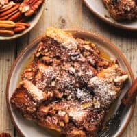 single serving of french toast casserole on plate with pecans in dish