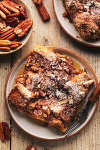 single serving of french toast casserole on plate with pecans in dish