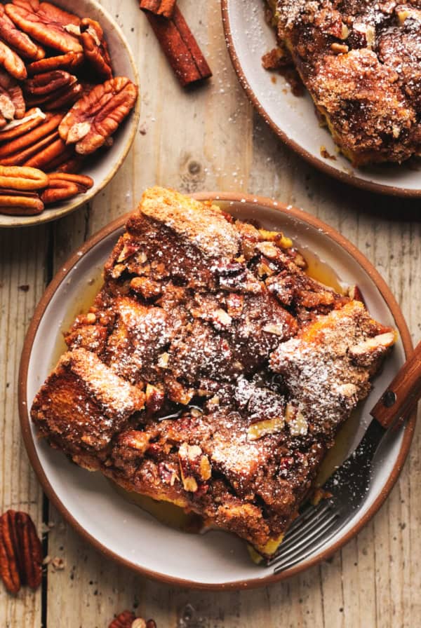 single serving of french toast casserole on plate with pecans in dish