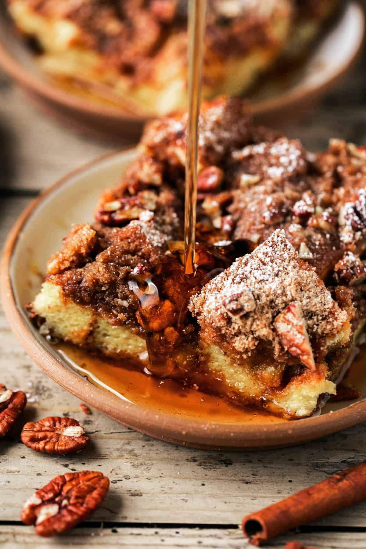 syrup pouring onto french toast bake with pecan topping