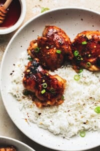honey garlic chicken thighs with steamed rice on plate