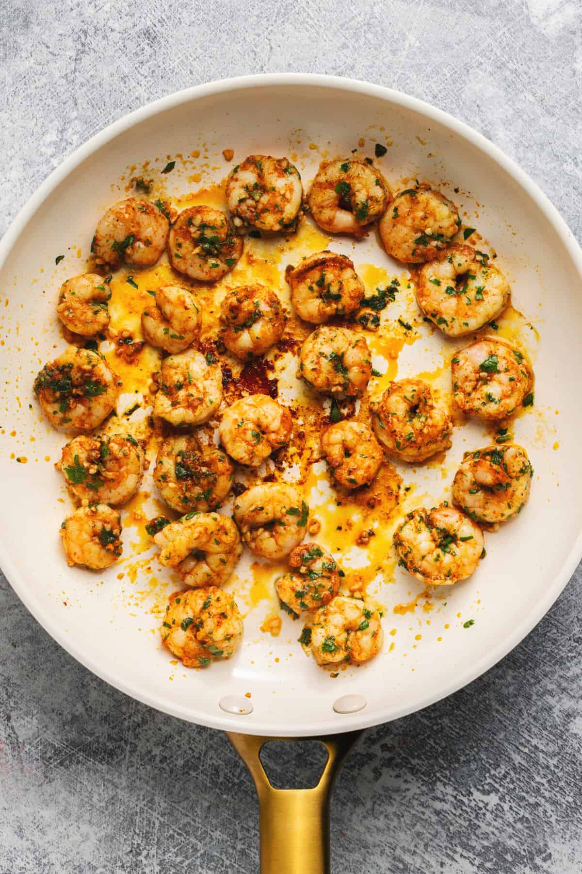 sauteed shrimp in skillet with seasoning and herbs