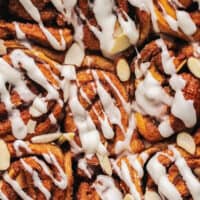 up close view of tops of cinnamon buns with icing drizzle