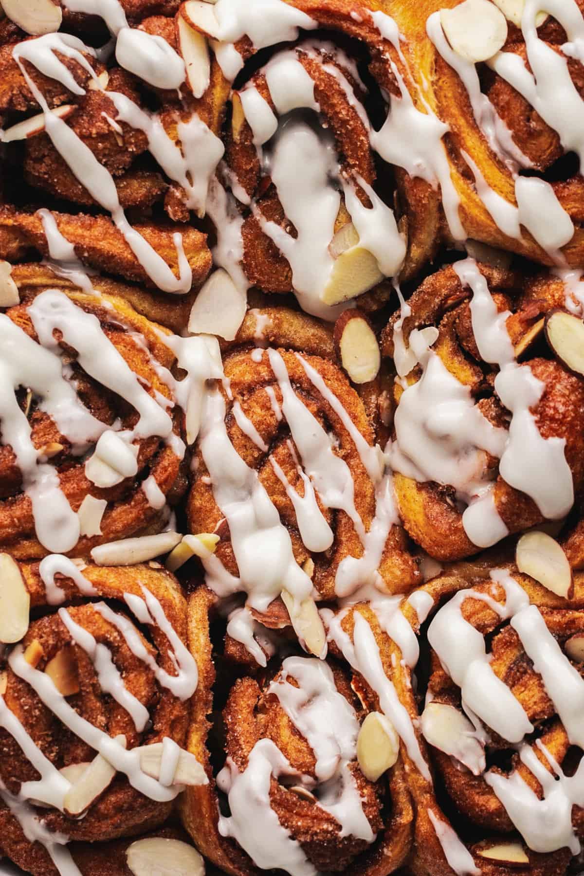 up close view of tops of cinnamon buns with icing drizzle