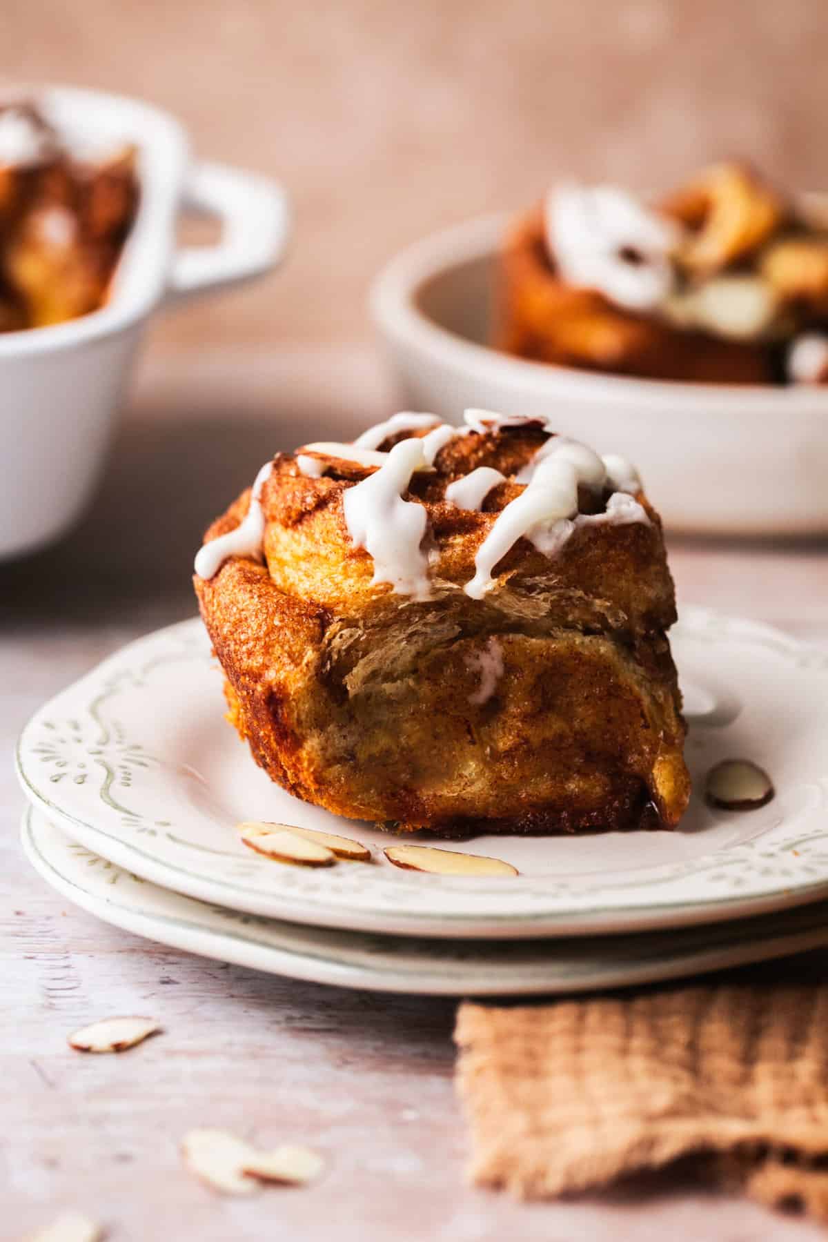 single cinnamon roll on two stacked plates