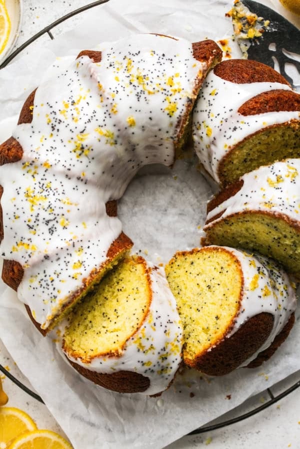 overhead view of sliced bundt cake with glaze and poppy seed garnish