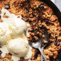 skillet pizookie with two spoons and ice cream