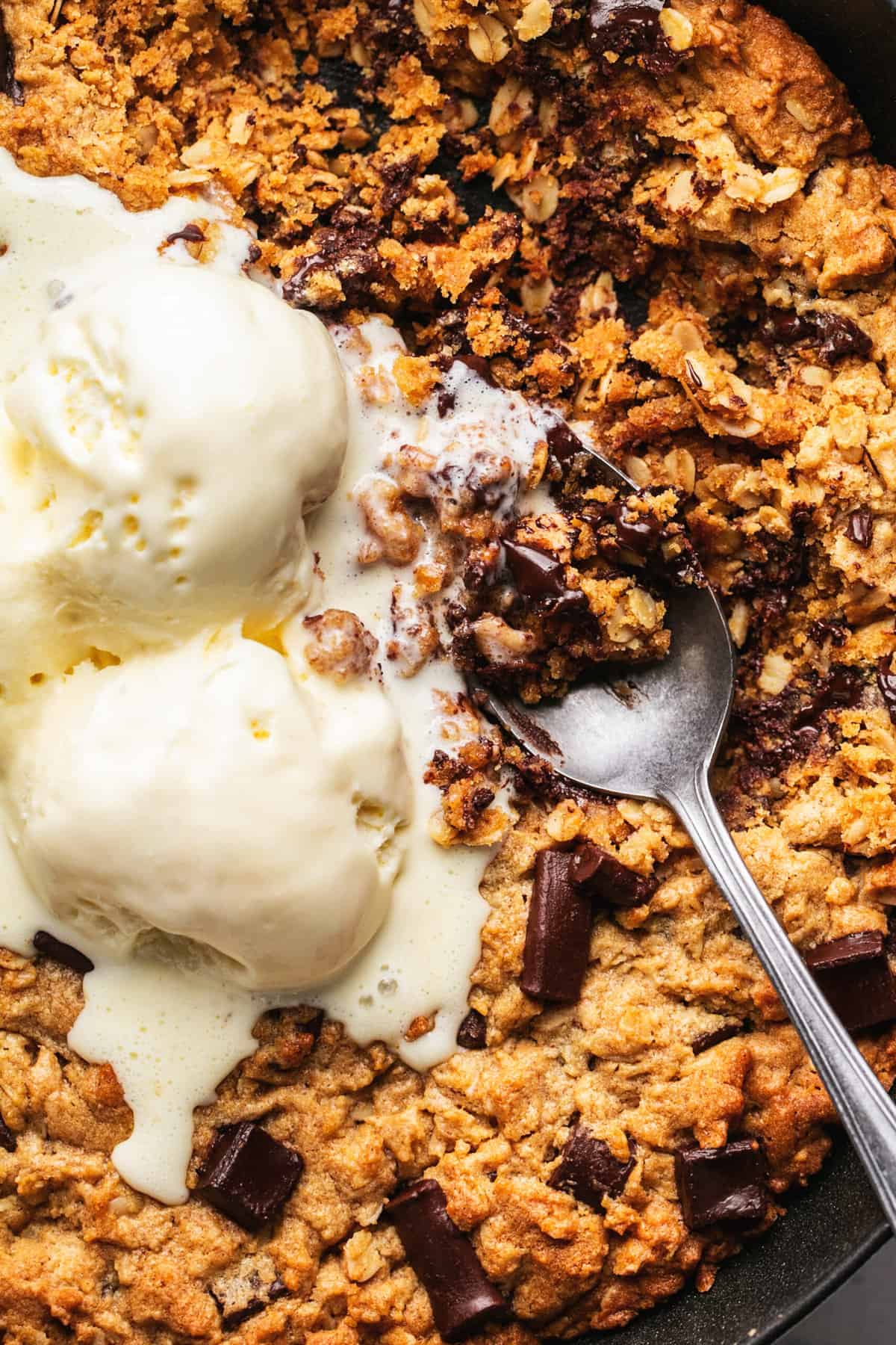 spoon digging into oatmeal cookie and ice cream