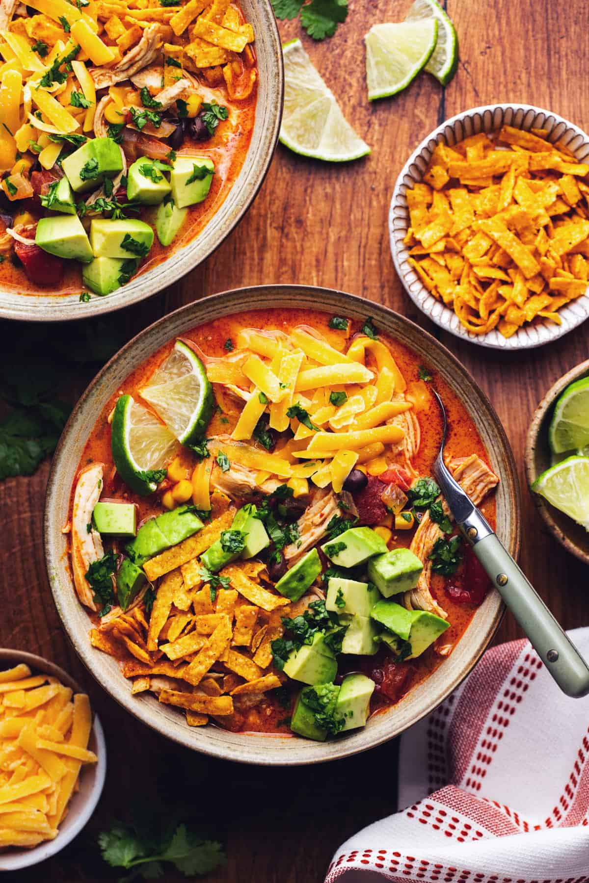 two bowls of creamy chicken tortilla soup with toppings