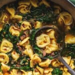 ladle scooping tortellini and sausage soup