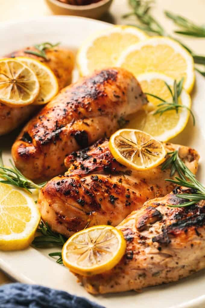 up close view of baked chicken breasts with lemons
