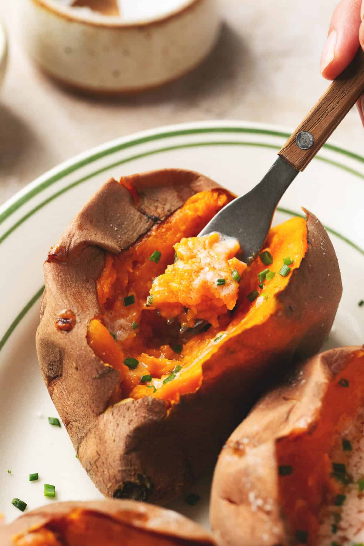 cooked sweet potato on plate with fork scooping inside