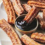 churro dipping into chocolate sauce in bowl