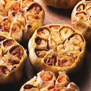 roasted garlic cloves on a wooden background