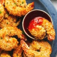 baked coconut shrimp on plate with sweet and sour sauce in cup